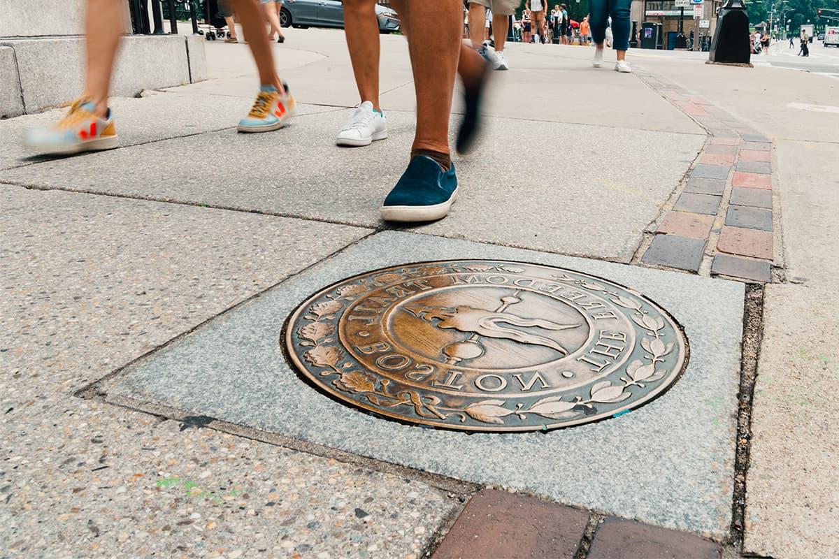 Freedom trail viewed from street level, feet on sidewalk.